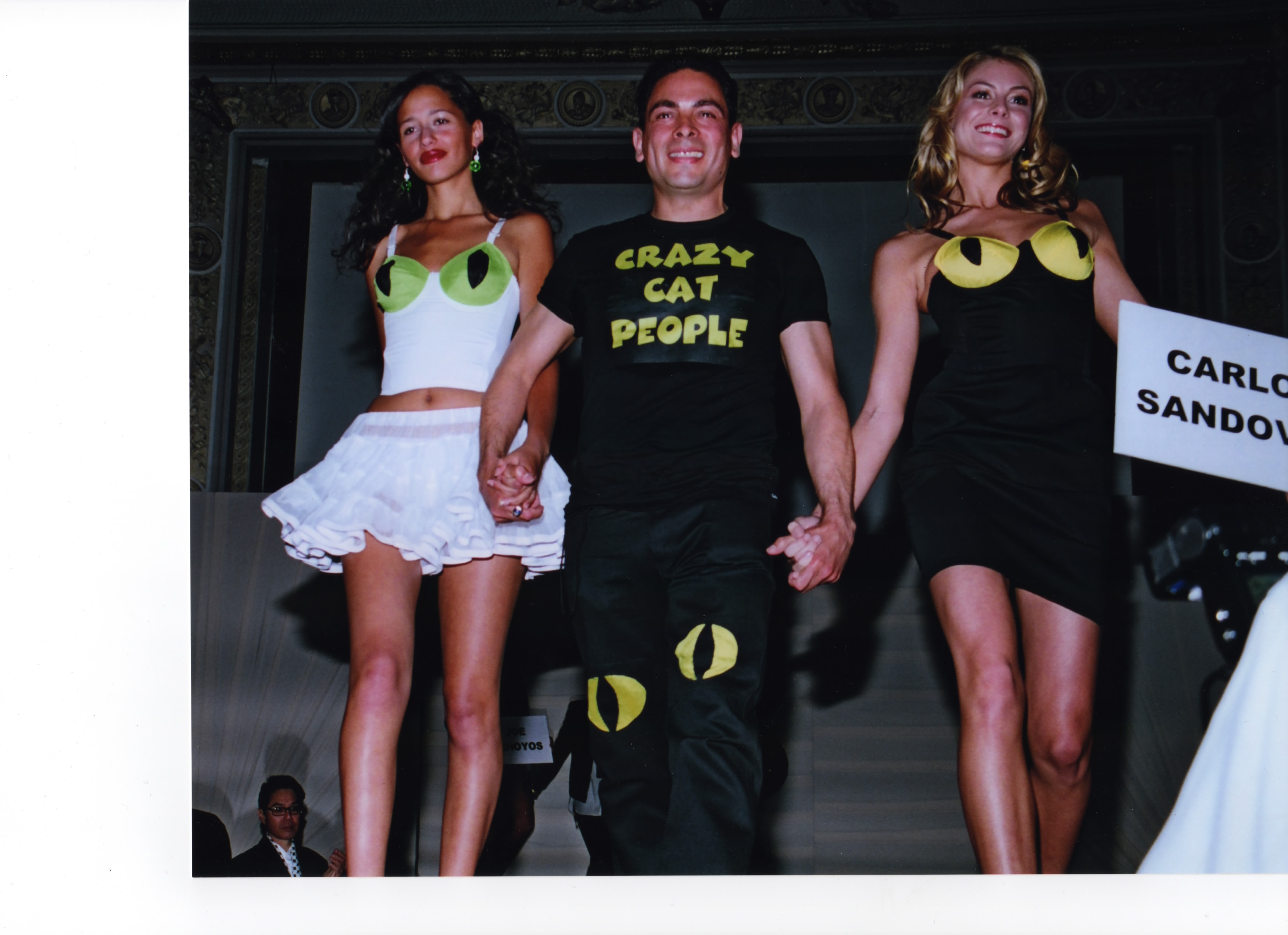 Illustrator Carlos Sandoval with two models wearing crazy cat people dresses