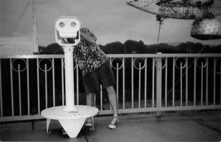 self portrait at Arecibo telescope in Puerto Rico - with telescope in background and to one side I am looking towards the camera with tourist binoculars
